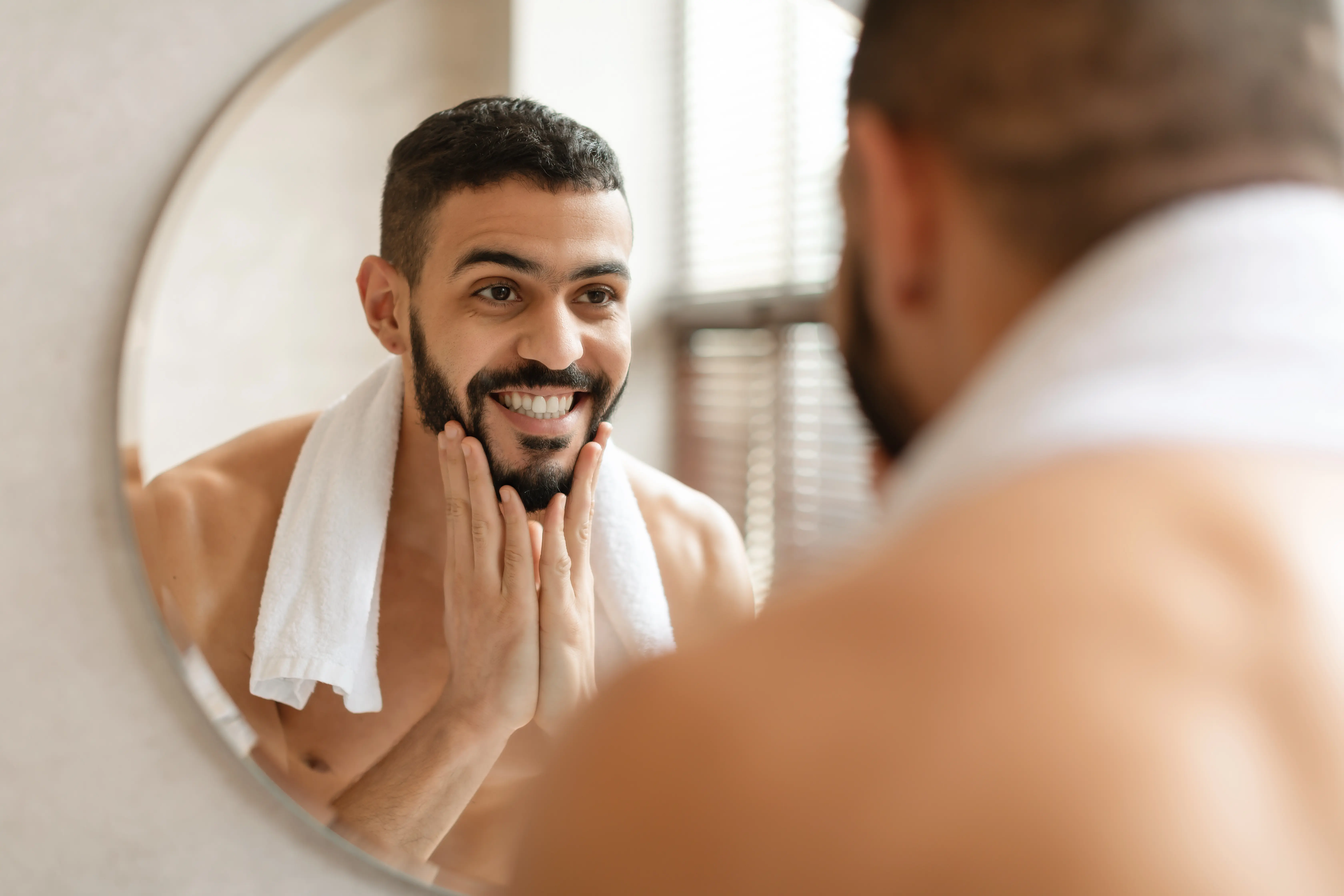 confident young arab guy looking in the mirror