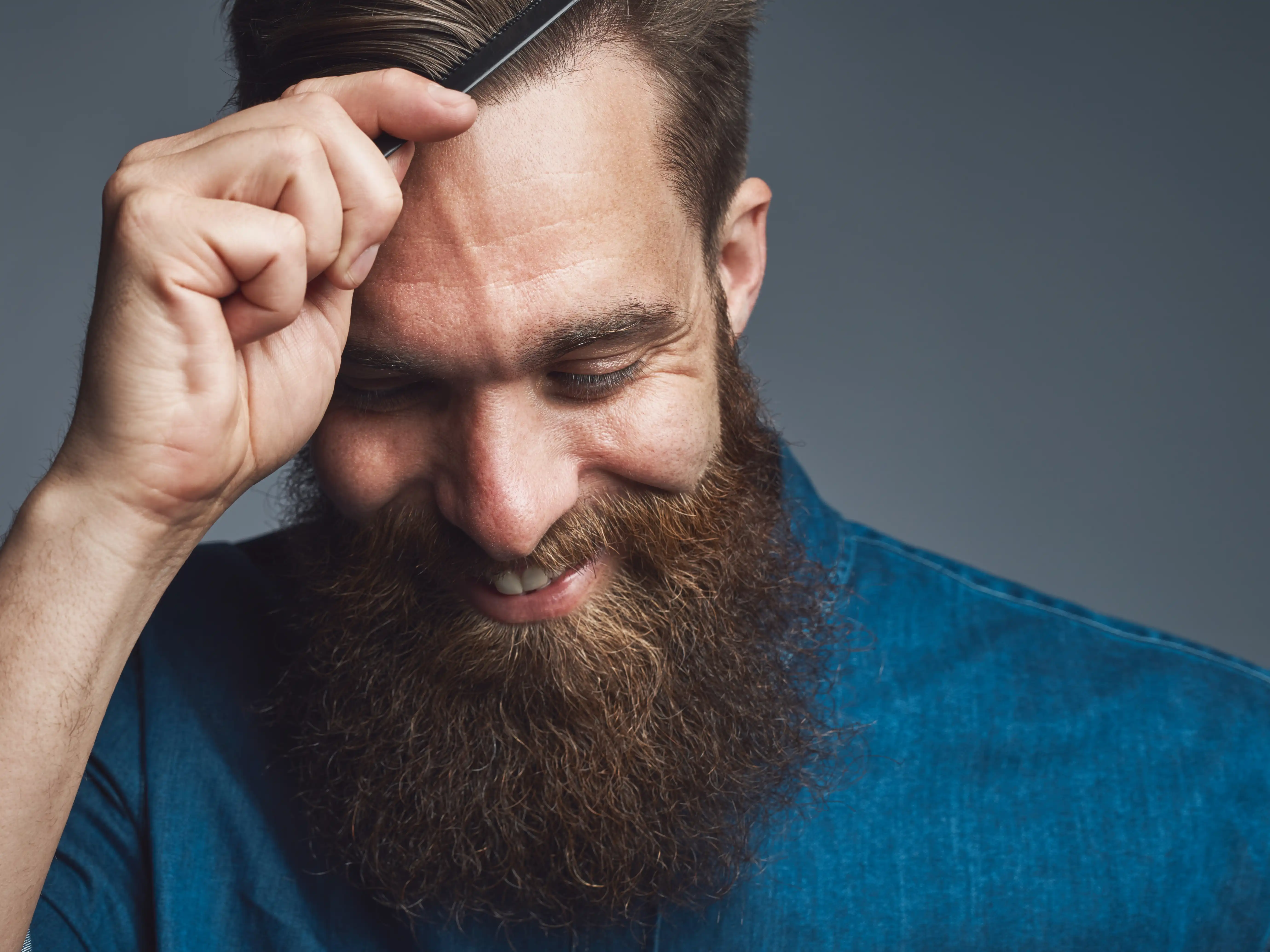 happy-bearded-man-combing-his-hair